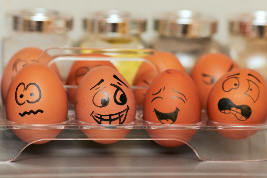 Eggs with cartoon faces in a fridge