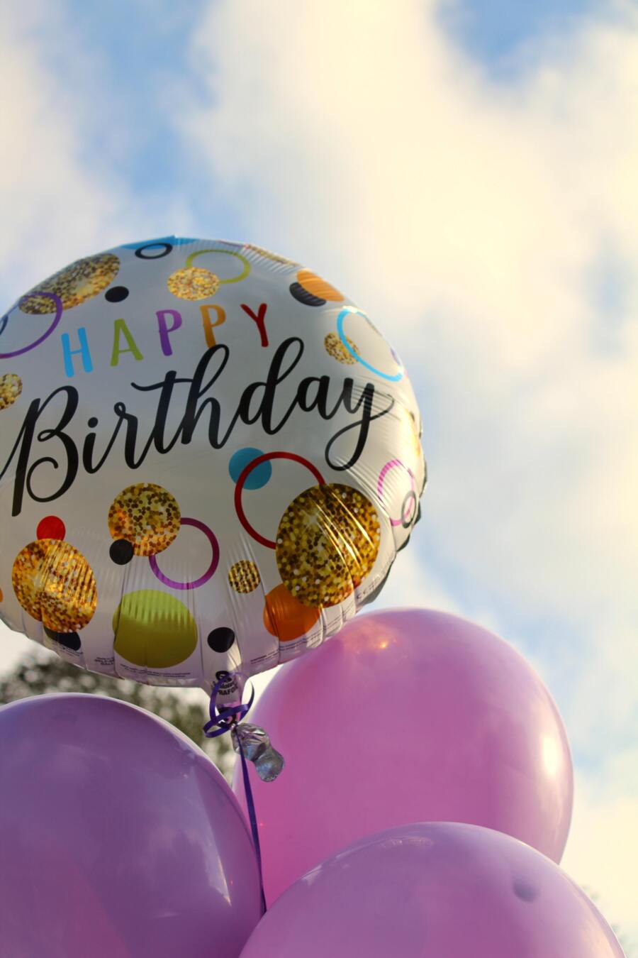 birthday balloons under a cloudy sky