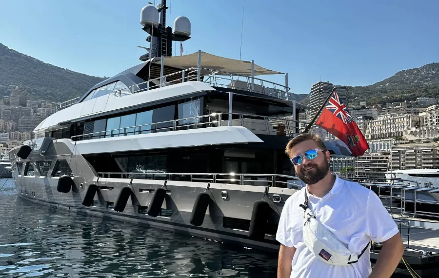 Göksel in front of a yacht