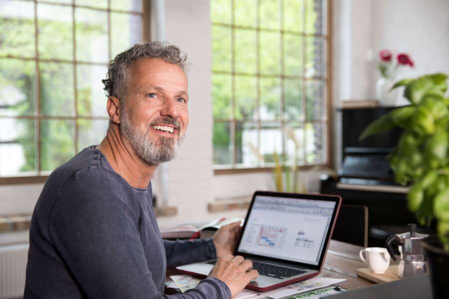 mature maritime engineer working at a laptop